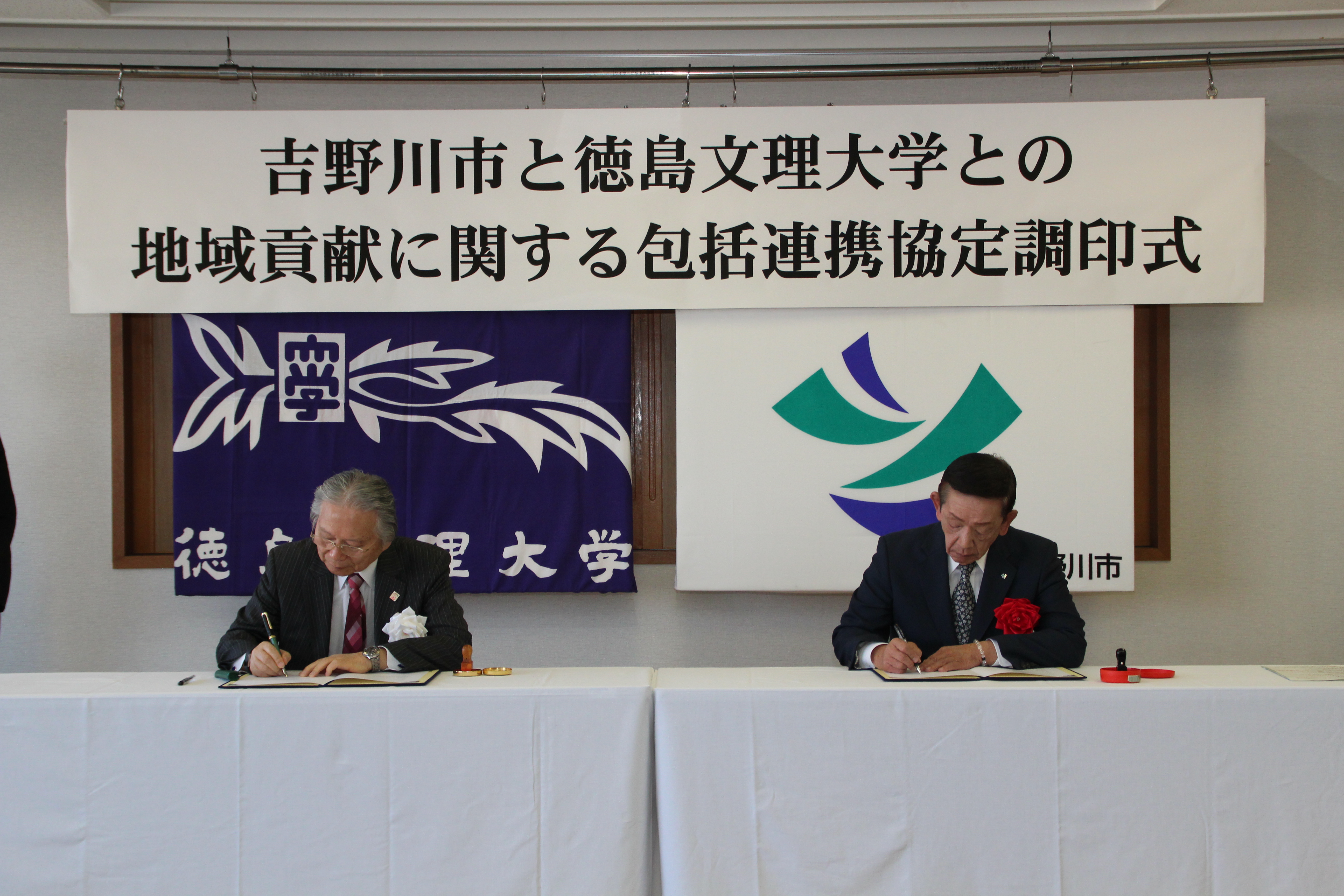 協定書に署名、押印をする徳島文理大学桐野学長と市長